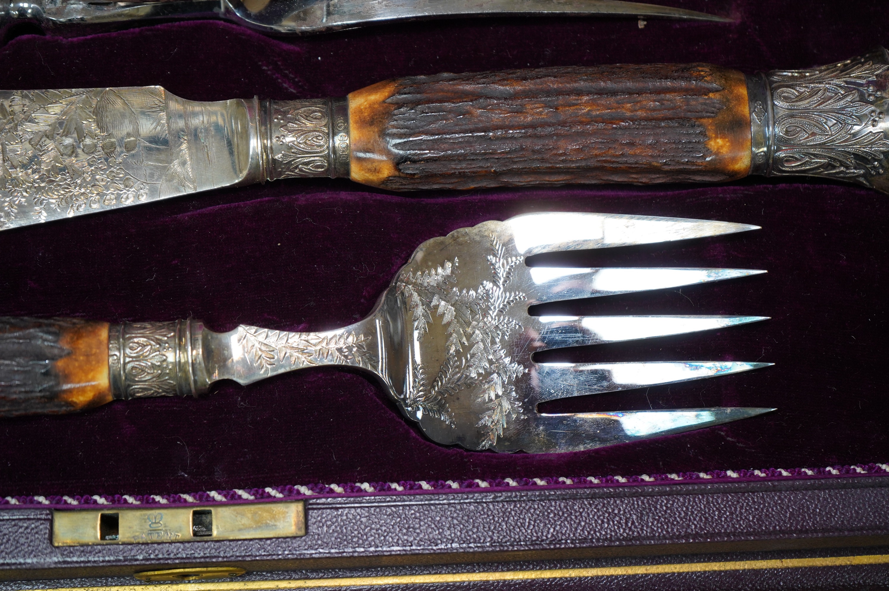 A gilt tooled leather cased stag handled silver collared carving set, case 44cm wide. Condition - good